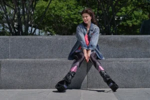 kobieta siedzi na schodach w parku i odczuwa objawy grzybicy pochwy